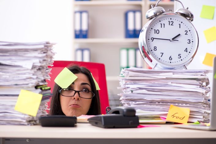 Young female employee in conflicting priorities concept